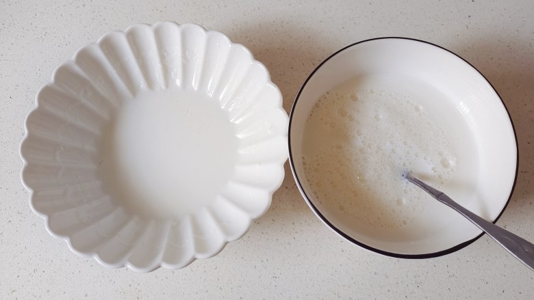 芒果双皮奶,凉好的牛奶用筷子揭开一点奶皮，将牛奶倒入蛋清中混合均匀，牛奶不要全部倒入蛋清中，留一点，防止奶皮贴在碗壁上