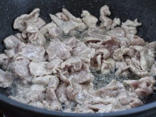 家常炒肉片,锅中倒适量食用油烧热，将腌制好的肉片倒进锅中炒至发白断生状态。