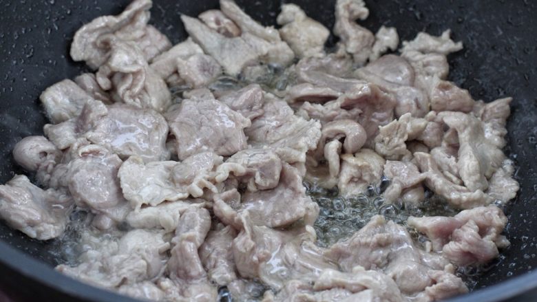 家常炒肉片,锅中倒适量食用油烧热，将腌制好的肉片倒进锅中炒至发白断生状态。