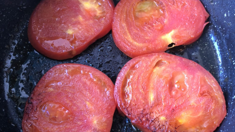 煎西红柿,煎制两面有点焦色即可。