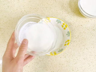 芒果双皮奶,小心地将奶皮下面的牛奶倒入另外一个碗里，不要全部倒完，留下小量的牛奶和奶皮，以防奶皮粘住碗上