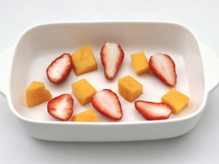 水果燕麦酸奶冰淇淋,容器底部铺上芒果块和草莓。