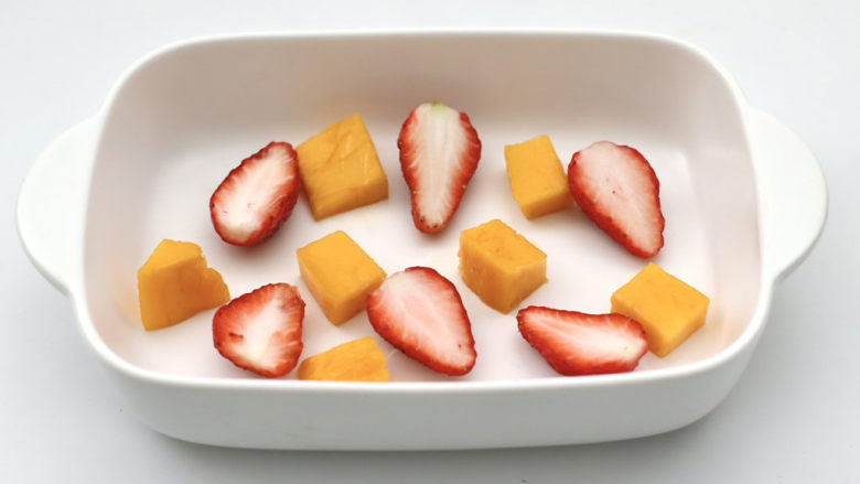 水果燕麦酸奶冰淇淋,容器底部铺上芒果块和草莓。