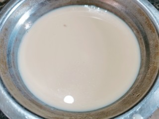 芒果双皮奶,过一遍筛子之后再用筷子挑起奶皮，再把牛奶轻轻地倒回原来的碗里