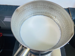 芒果双皮奶,将牛奶倒入锅中，小火煮至边缘起泡泡