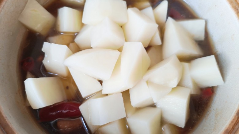 土豆焖鸭,下入土豆块搅拌均匀，小火炖10分钟。 