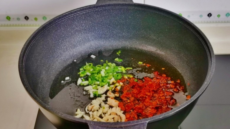 石锅豆腐,起油锅加入葱蒜辣椒碎炒香。