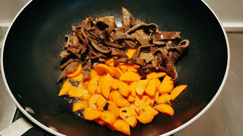 卤面条,起油锅放入食用油，油热后放入胡萝卜片和榛蘑翻炒2分钟。