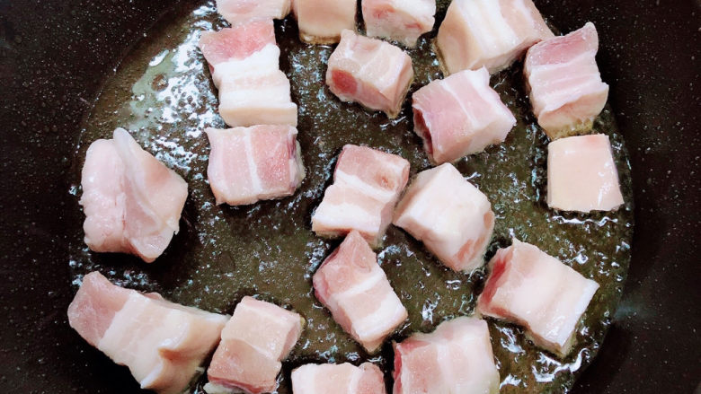 豆角焖肉,锅中倒入油，放入五花肉，慢煎。