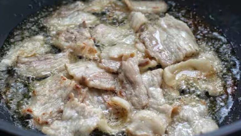 豆角焖肉,锅中倒适量食用油烧热，然后放入五花肉小火煸炒至出油打卷的状态。