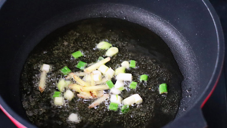 土豆炖鸡腿,热锅先爆香葱姜碎。