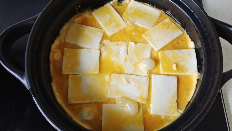 石锅豆腐,淋入鸡蛋液，待鸡蛋液几乎凝固
