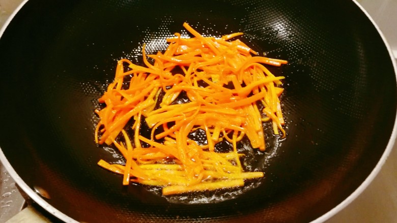 杏鲍菇炒肉丝,起油锅，放入食用油，油热后放入胡萝卜丝翻炒断生，盛出备用。