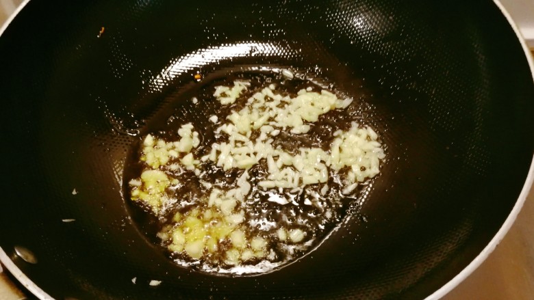 杏鲍菇炒肉丝,锅中底油继续加热，放入蒜碎翻炒出香味。