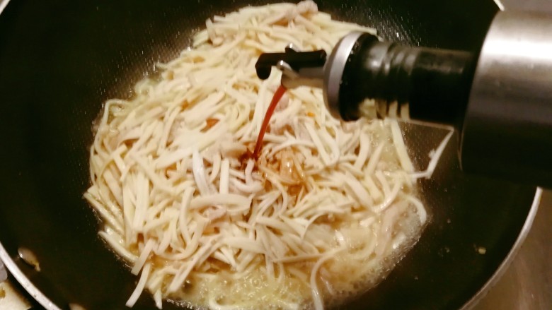 杏鲍菇炒肉丝,倒入酱油提味。