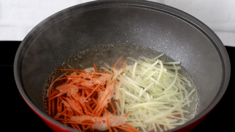低卡饱腹的生菜卷,锅中倒入适量清水加少许盐烧开，放入土豆和胡萝卜丝烫熟。