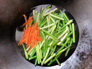 凉拌蒜苗,将胡萝卜去皮切丝、蒜苗切段，锅烧沸水将食材加入其中，焯熟变软后捞出。