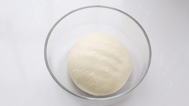 奶香小面包,将面团整理好放进容器中，覆盖保鲜膜放温暖处进行基础发酵。