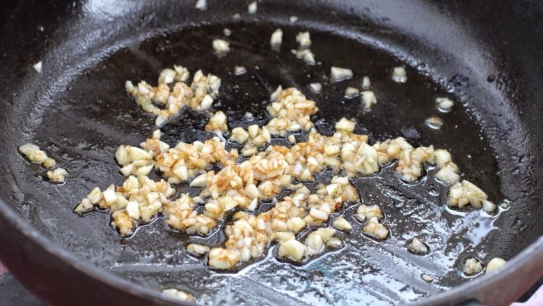 煎酿辣椒,就着锅中底油放入蒜末，小火炒出香味来，注意别炒糊了。