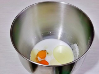 奶香 小面包,首先将牛奶，玉米油，草鸡蛋，盐与糖加入厨师机桶中。