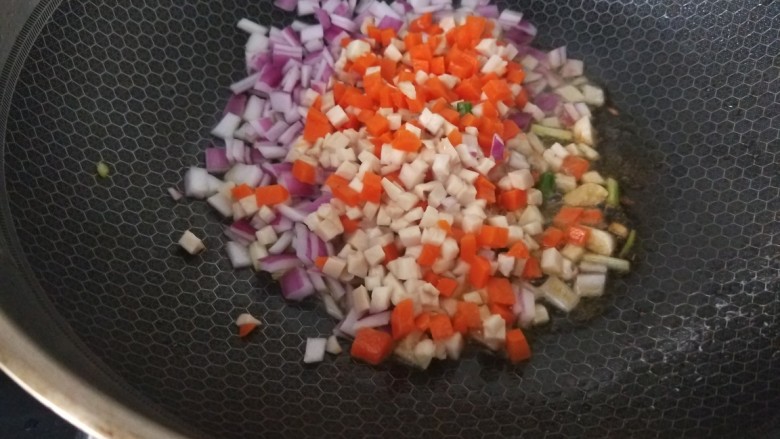 彩蔬火腿丁,下入胡萝卜，杏鲍菇，洋葱，豌豆丁进行翻炒