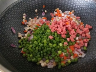 彩蔬火腿丁,最后下入蒜苔，火腿丁进行翻炒
