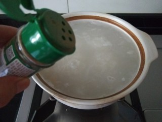 生滚鱼片粥,放入白胡椒粉。