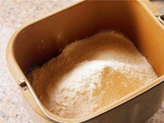 奶香小面包,将主材料里除黄油外的其他材料按照先液体的顺序放到面包桶里。