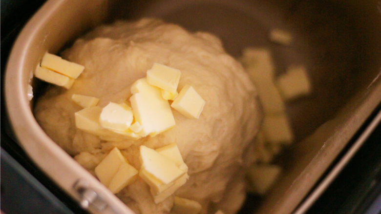 奶香小面包,面团揉至一定的延展性，加入黄油继续揉。