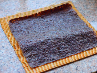 饭卷,将海苔铺在寿司帘上。