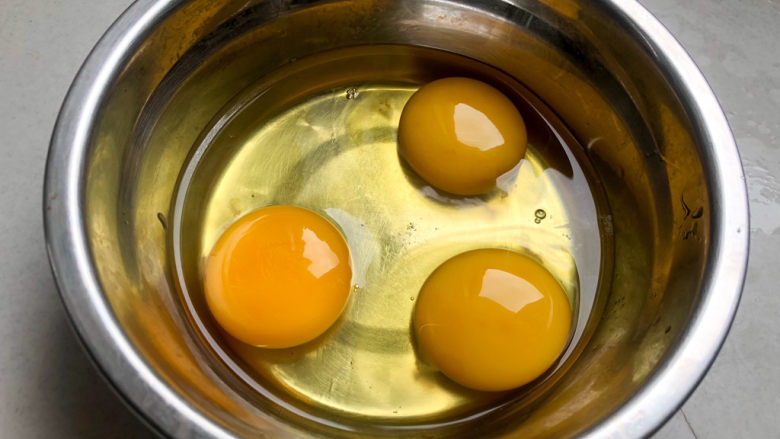 虾仁韭菜炒鸡蛋,碗中打入三个鸡蛋，将鸡蛋打散。