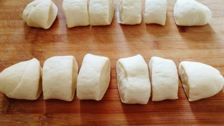 奶香小面包,取出面团在面板上轻按排气，等分12份。