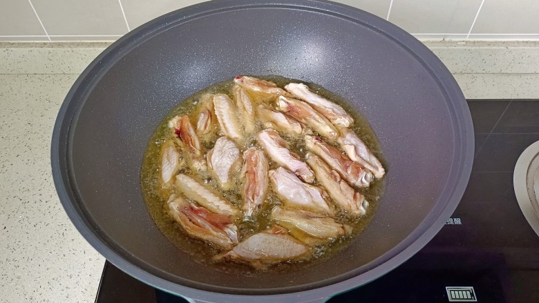 柠香鸡翅,锅里放宽油，油温五成热放入鸡翅煎。