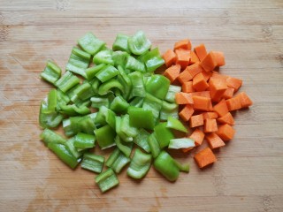 彩蔬火腿丁,青椒洗干净去籽，和胡萝卜分别切成丁。