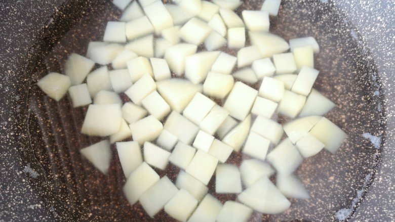 彩蔬火腿丁,锅里放水烧开，加入一勺盐，下入土豆丁焯水至熟，盛出备用。