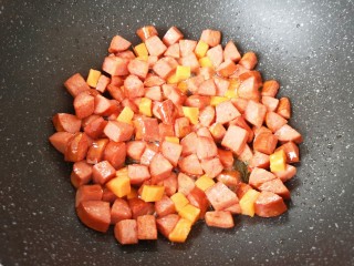 彩蔬火腿丁,下入胡萝卜翻炒均匀。