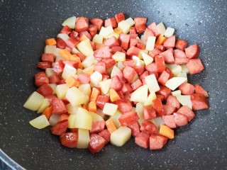 彩蔬火腿丁,下入土豆翻炒均匀。