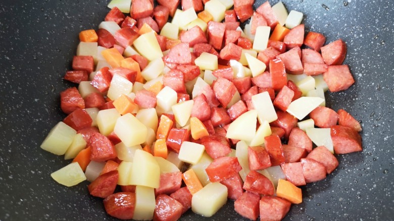 彩蔬火腿丁,下入土豆翻炒均匀。