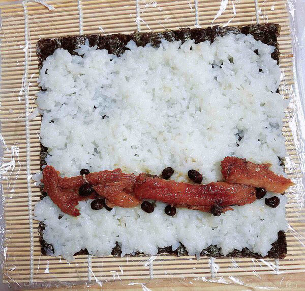 饭卷,米饭上放上豆豉鳗鱼肉。
