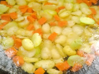 彩蔬火腿丁,再加入蚕豆仁煮至变色