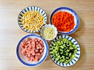 彩蔬火腿丁,火腿肠切丁，玉米掰粒，胡萝卜和黄瓜切丁，蒜切末