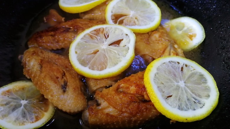 柠香鸡翅,放入柠檬片，翻炒均匀，文火焖煮5分钟。