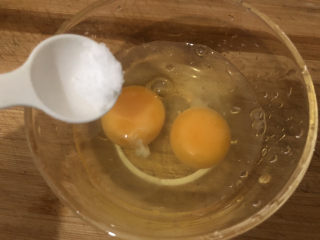 虾仁韭菜炒鸡蛋,碗里打入鸡蛋加点盐搅散
