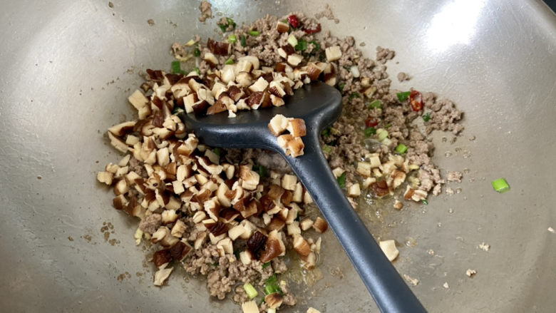 肉末辣炒玉米粒,加入香菇粒，中火煸炒一分钟