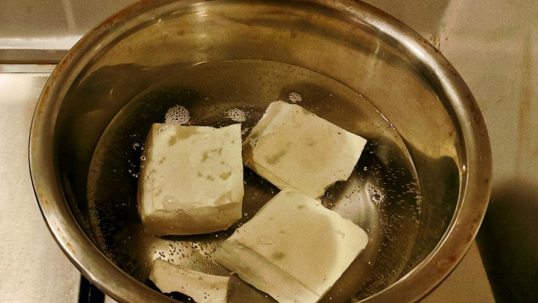 椒盐豆腐,豆腐放入开水中煮2分钟，捞出切块备用。