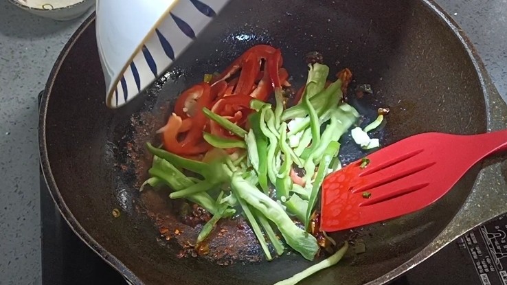 鱼香茄子盖饭,放入青红椒煸炒均匀