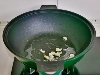 双椒手撕包菜,起油锅加入蒜末煸炒。