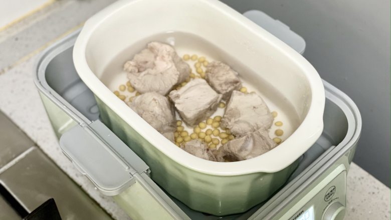 苦瓜黄豆猪骨汤，清热解暑，夏天喝一碗，清爽不油腻,把猪骨和泡好的黄豆放入炖盅，加入适量清水，没过食材，盖好盖子，炖50分钟。

