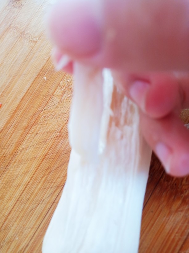 干煸手撕杏鲍菇,用手顺着杏鲍菇的纹路撕成小条。
