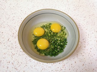 野菜鸡蛋饼,将小蒜碎放入大碗里，打入鸡蛋。